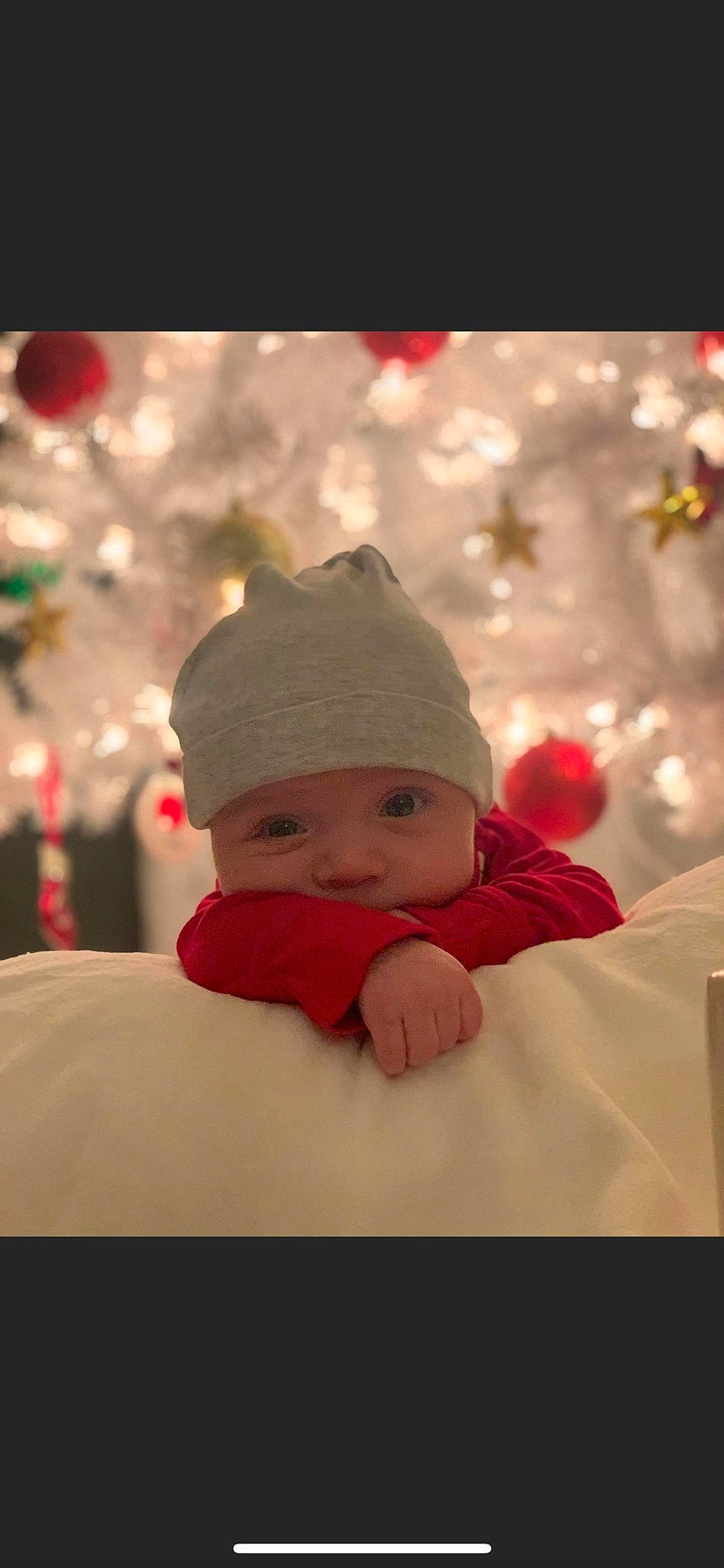 Logan is registered to the contest to win money with this photo: baby, baby_toddler_clothing, cap, carmine, child, christmas, christmas_decoration, christmas_eve, christmas_ornament, comfort, event, freezing, fun, happy, headwear, holiday, ornament, person, sitting, toddler