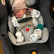 Emilia is registered to the contest to win money with this photo: baby, car, car_interior, carseat, clothing, face, hat, head, infantbed, person, transportation, vehicle, yawning