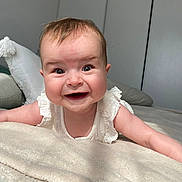 Juliette a rejoint le concours — aidez-le/la à gagner de superbes lots ! baby, smiling, face, blanket, pillow, infant, happy, arms, skin, head, expression, indoors, child, cute, clothing, white, person, portrait, bedroom, soft