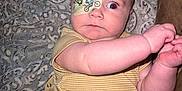 Coltyn is registered to the contest to win money with this photo: baby, infant, eye_patch, blanket, yellow_clothing, onesie, diaper, arm, face, wide_eyes, patterned_blanket, indoor, couch, cute, child, expression, skin, person, young, lying_down