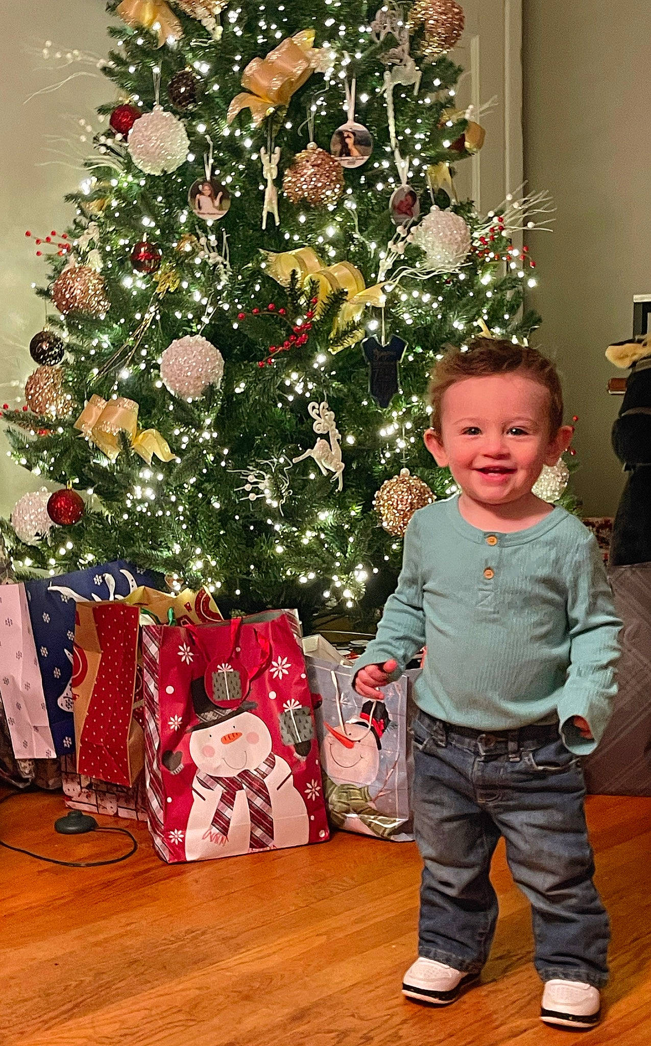 Grayson is registered to the contest to win money with this photo: baby_toddler_clothing, christmas, christmas_decoration, christmas_eve, christmas_ornament, christmas_tree, event, evergreen, holiday, holiday_ornament, joy, leaf, living_room, ornament, person, plant, red, smile, toddler, tree