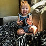 Phoebe is registered to the contest to win money with this photo: baby, bed, bodypart, clothing, couch, cushion, electronics, face, finger, furniture, hand, head, homedecor, indoors, pants, person, phone, photography, portrait, sitting