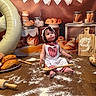 Annaya joined the competition — help win amazing prizes! baby, child, baking, flour, bread, pastries, rolling_pin, wooden_spoon, apron, balloon, table, food, celebration, kitchen, cute, smiling, indoors, portrait, decorations, anniversary