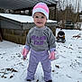 child, toddler, snow, winter_clothing, knit_hat, mittens, purple_pants, gray_sweatshirt, smile, standing, backyard, shed, plastic_chair, leaf_litter, trees, overcast_sky, boots, toy_equipment, cold, rosy_cheeks