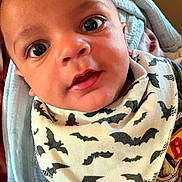 Troy joined the competition — help win amazing prizes! baby, infant, close_up, face, eyes, bib, bat_pattern, clothing, blanket, skin, expression, person, cute, indoors, portrait, young_child, head, mouth, cheeks, baby_bib