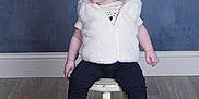 Rozalyn is registered to the contest to win money with this photo: black_pants, child, cute, ear_piercing, gray_backdrop, happy, indoor, pigtails, pink_socks, playful, portrait, red_hair, sitting, smiling, stool, studio_portrait, toddler, white_fur_vest, white_shoes, wooden_floor