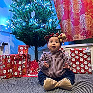 Nahia joined the competition — help win amazing prizes! baby, child, christmas_tree, holiday, presents, gift_wrap, carpet, headband, indoor, festive, decorations, smiling, clothing, cute, celebration, holiday_lights, home, portrait, winter, seasonal