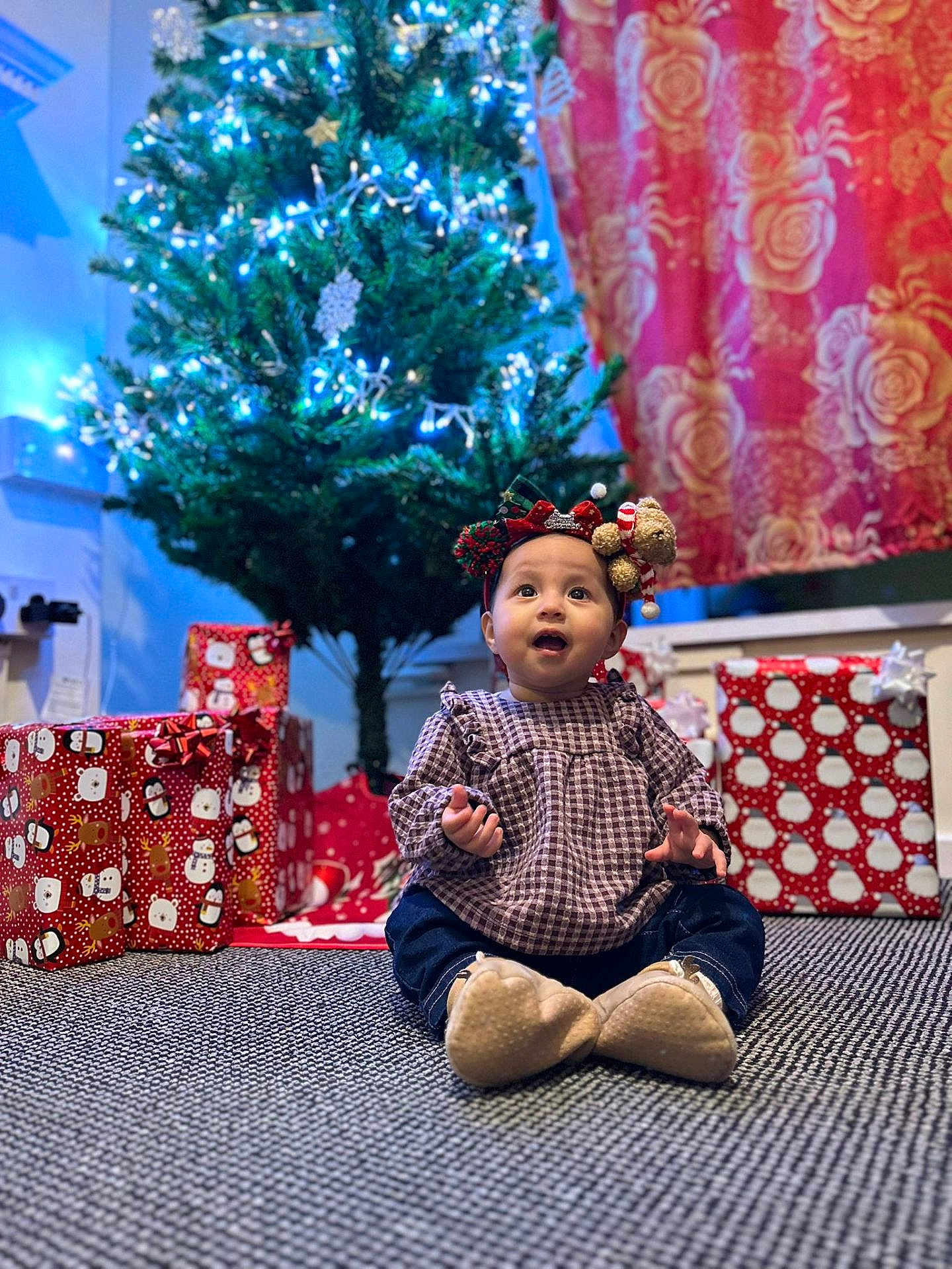 Nahia joined the competition — help win amazing prizes! baby, child, christmas_tree, holiday, presents, gift_wrap, carpet, headband, indoor, festive, decorations, smiling, clothing, cute, celebration, holiday_lights, home, portrait, winter, seasonal