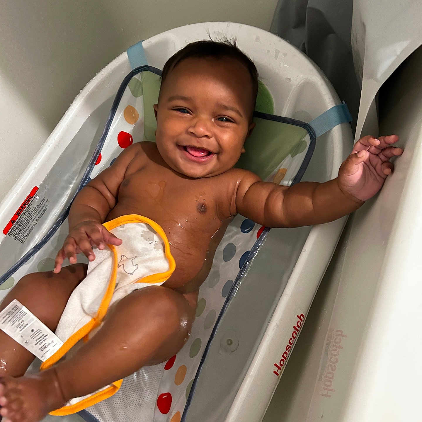 Zharron joined the competition — help win amazing prizes! baby, bath_time, bathtub, child, colorful, cute, foot, hand, happy, indoor, infant, person, plastic, playful, portrait, sitting, skin, smiling, towel, water