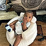 baby, infant, child, sitting, indoor, inflatable_seat, sock, hand, curious, face, furniture, couch, pattern, carpet, clothing, relaxed, cute, home, toddler, resting