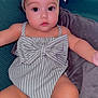 Lycia participe au concours pour gagner de l'argent avec cette photo : baby, child, bow, headband, romper, striped_clothing, chair, cushion, indoors, cute, person, infant, relaxed, seated, plump, skin, face, eyes, arm, legs