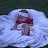 baby, infant, child, sleepy, sitting, blanket, bedding, white_blanket, red_shirt, headband, grass, outdoor, portrait, face, hands, legs, cozy, candid, soft_focus, vintage