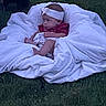 baby, infant, child, portrait, blanket, white_blanket, grass, outdoor, lying_down, sitting, headband, red_shirt, sleeping, face, arms, legs, baby_photography, soft_fabric, lawn, natural_light