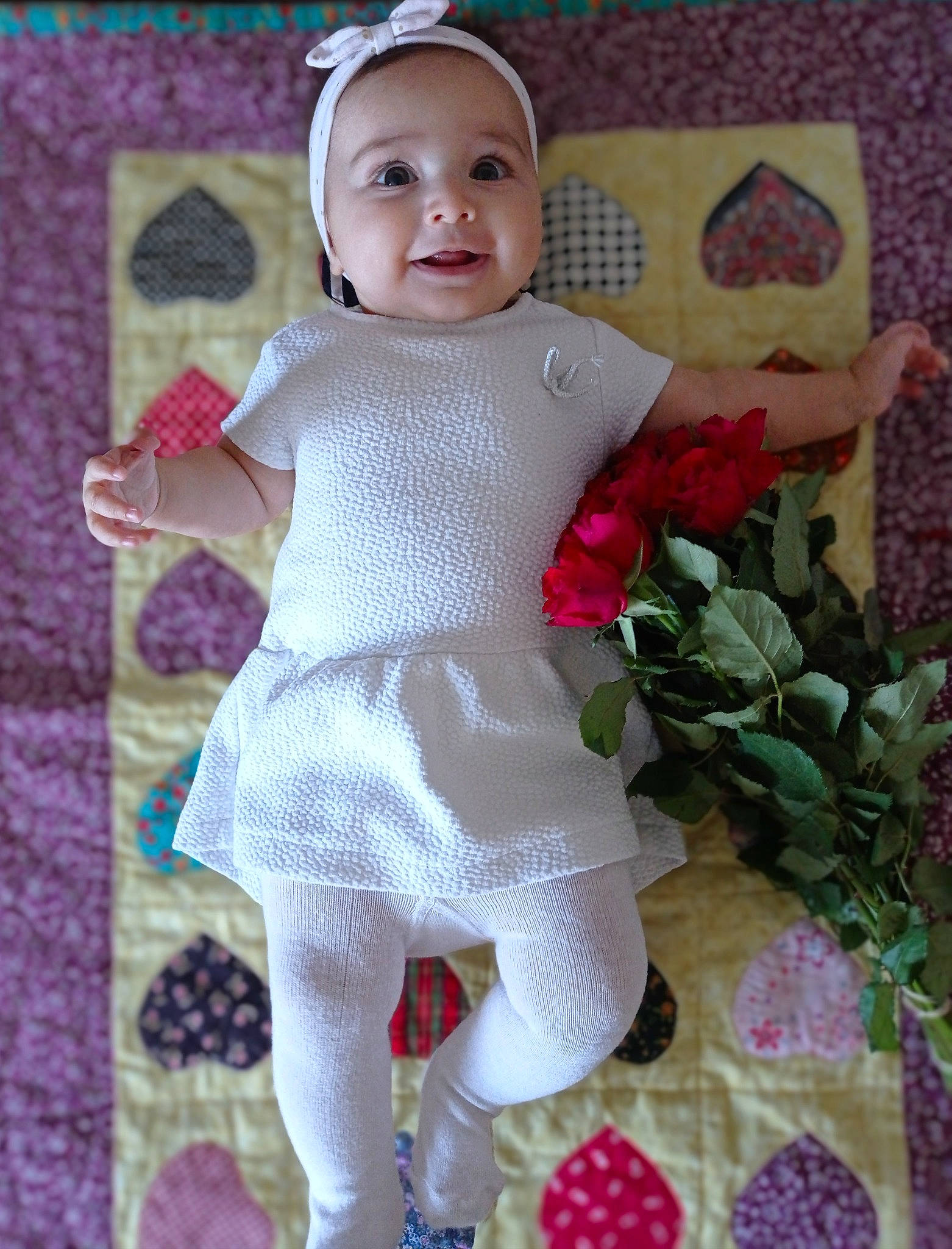 Pauline participe au concours pour gagner de l'argent avec cette photo : baby, baby_products, baby_toddler_clothing, cheek, child, creative_arts, face, head, headwear, linens, magenta, pattern, person, petal, pink, purple, rose, skin, sleeve, smile