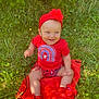 baby, child, smiling, red_clothing, headband, outdoor, grass, blanket, sunlight, nature, greenery, happy, sitting, footwear, cute, infant, person, flower, headwear, summer
