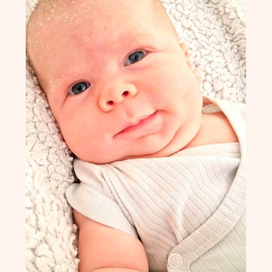 Helio a rejoint le concours — aidez-le/la à gagner de superbes lots ! arm, baby, blanket, blue_eyes, child, close_up, cute, face, indoors, infant, newborn, person, portrait, resting, skin, sleepwear, smiling, soft_texture, white_clothing, young_child