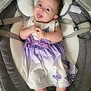 Lina a rejoint le concours — aidez-le/la à gagner de superbes lots ! baby, child, infant, dress, purple, butterfly, socks, smiling, tongue_out, seat, cushion, gray, clothing, cute, happy, person, indoors, baby_seat, playful, portrait
