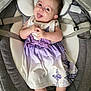 baby, child, infant, dress, purple, butterfly, socks, smiling, tongue_out, seat, cushion, gray, clothing, cute, happy, person, indoors, baby_seat, playful, portrait