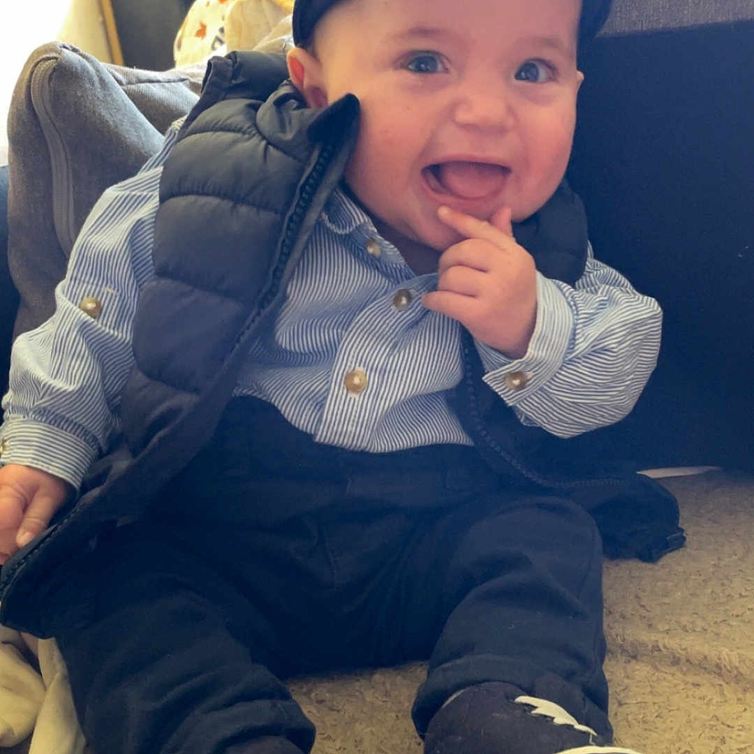 Klayton a rejoint le concours — aidez-le/la à gagner de superbes lots ! baby, blanket, cap, casual, child, clothing, cushion, cute, face, happy, home, indoor, infant, person, playful, portrait, shoes, sitting, smiling, vest