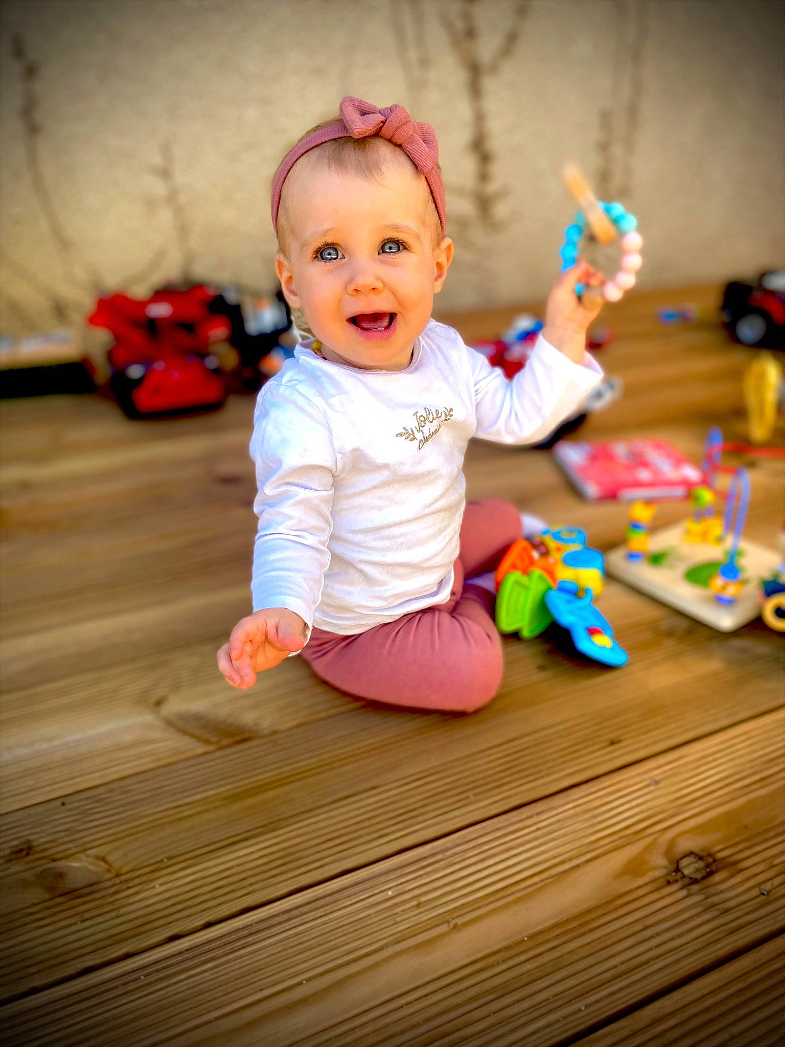 Kélya participe au concours pour gagner de l'argent avec cette photo : baby, baby_toddler_clothing, cheek, child, face, flash_photography, flooring, fun, happy, hardwood, head, person, pink, plant, play, room, sitting, skin, smile, toddler