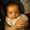 Phakin is registered to the contest to win money with this photo: baby, infant, car_seat, bib, hands, clasped_hands, face, expression, indoor, clothing, warning_label, seatbelt, child, portrait, young, cute, skin, head, hair, person