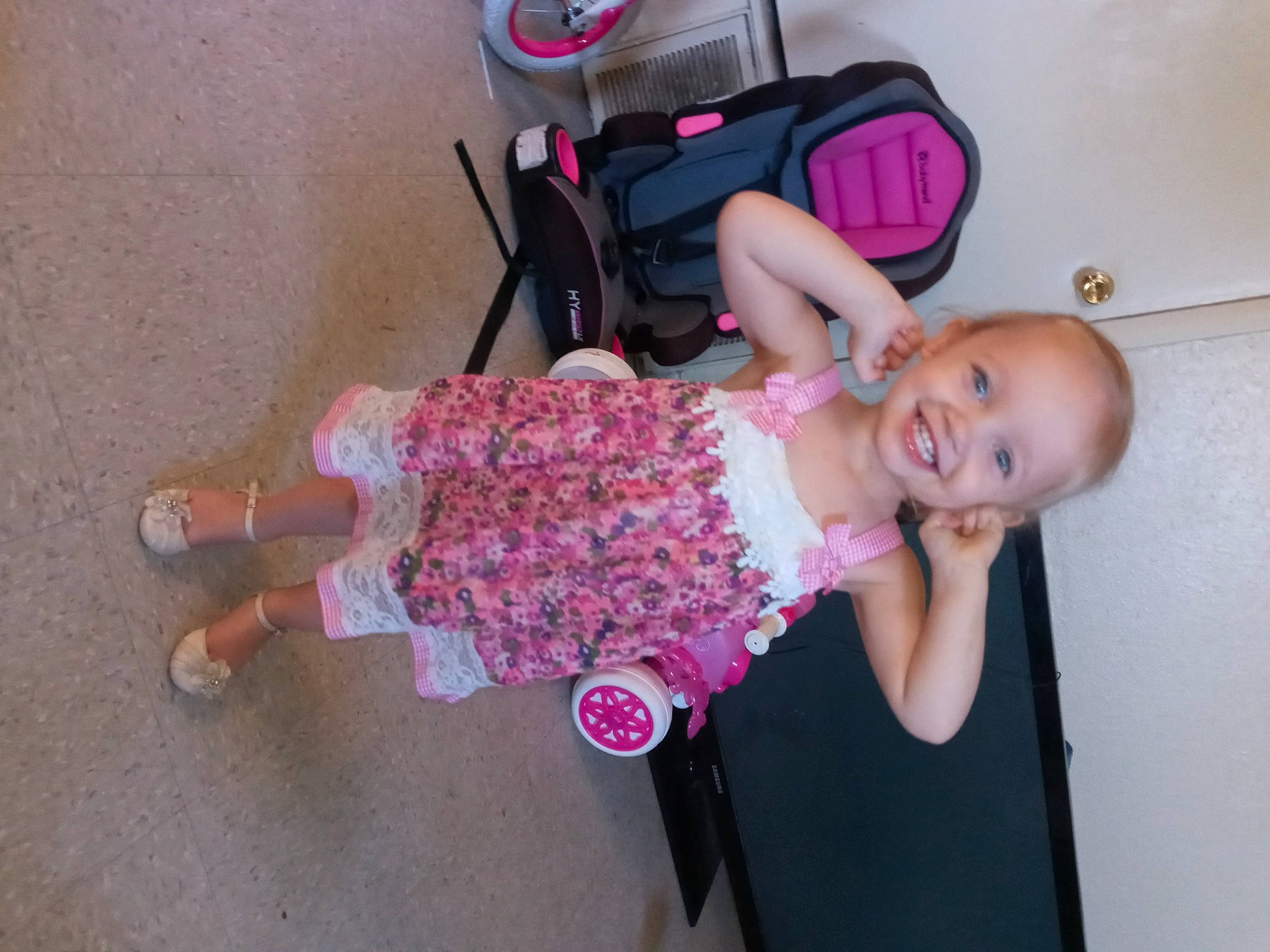 Koda is registered to the contest to win money with this photo: arm, baby, baby_products, baby_toddler_clothing, cheek, child, facial_expression, fun, happy, joy, luggage_and_bags, magenta, pattern, person, pink, product, shoe, sitting, skin, smile