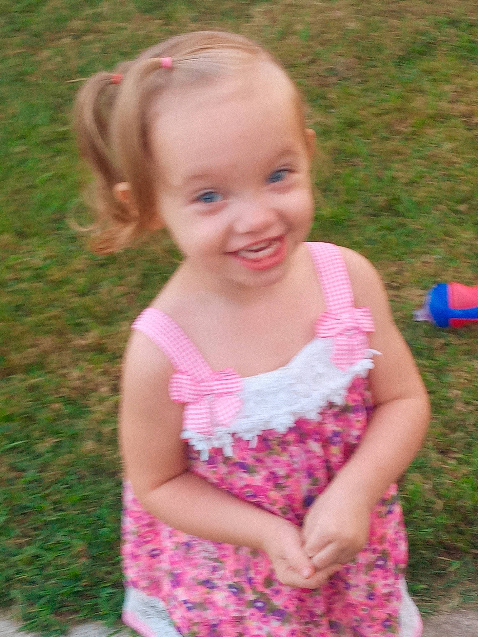 Koda is registered to the contest to win money with this photo: baby_toddler_clothing, child, clothing, dress, face, facial_expression, grass, happy, human_body, iris, joy, mammal, meadow, people_in_nature, person, pink, plant, skin, sleeve, smile