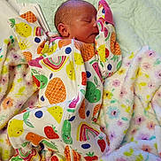 Isabelle joined the competition — help win amazing prizes! newborn, baby, sleeping, onesie, fruit_pattern, blanket, floral_blanket, cozy, infant, cute, soft_texture, child, sleep, peaceful, colorful_clothing, indoors, portrait, resting, young, person