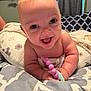 baby, infant, smiling, teething_toy, pillow, blanket, indoors, child, cute, happy, face, skin, hand, blue_eyes, plush, lying_down, soft, closeup, person, toddler