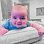 baby, smiling, face, child, cushion, blue_shirt, indoor, blanket, happy, portrait, chubby_cheeks, infant, tummy_time, furniture, room, door, soft_lighting, closeup, cute, young_child