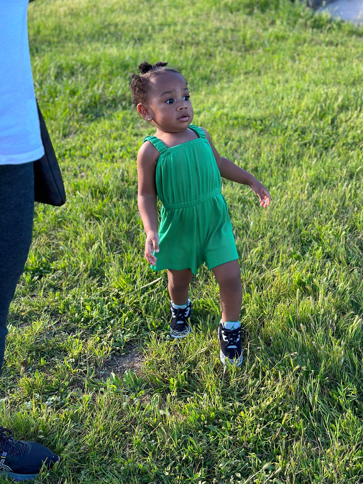 Noelle is registered to the contest to win money with this photo: baby_toddler_clothing, field, footwear, fun, gesture, grass, grass_family, grassland, happy, lawn, leisure, meadow, people_in_nature, person, plant, recreation, shoe, shorts, sneakers, sunlight