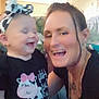 baby, black_clothing, candid, casual, child, cute, family, fun, happy, headband, indoor, interaction, joy, laugh, living_room, necklace, person, seated, smile, woman
