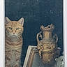 cat, orange_tabby, window, glass, vase, antique, decor, indoor, curious, pet, feline, portrait, still_life, frame, ornate, animal, whiskers, looking, sitting, domestic_cat