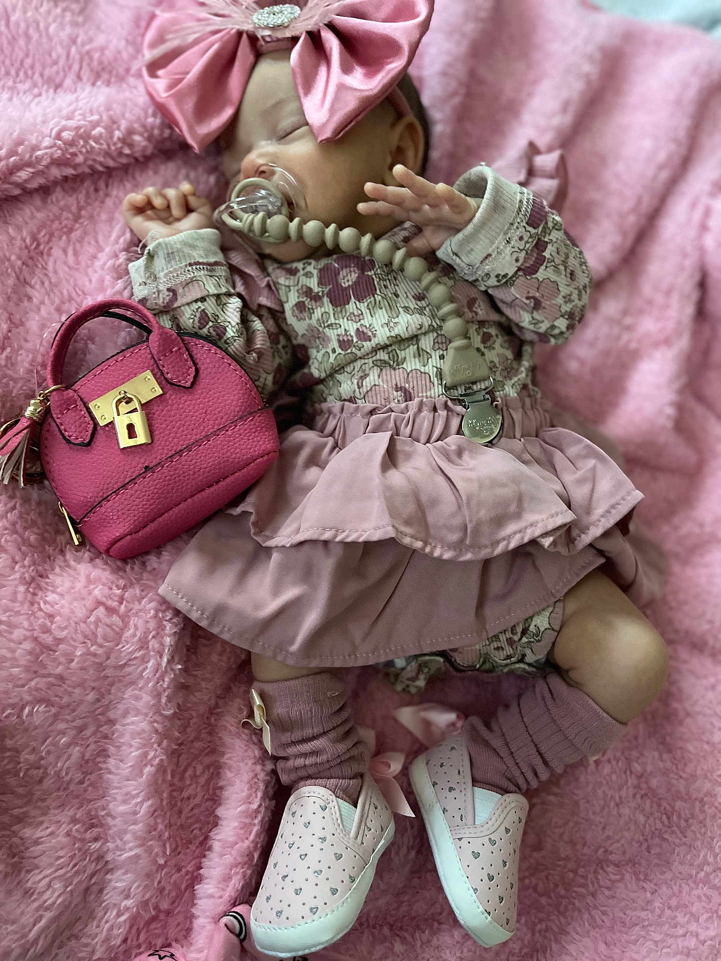 Leilani is registered to the contest to win money with this photo: baby, infant, sleeping, headband, bow, pacifier, pacifier_clip, beaded_chain, handbag, pink_blanket, dress, ruffle, socks, shoes, plush, fabric, closeup, portrait, accessory, cute