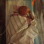 Phoenix is registered to the contest to win money with this photo: newborn, baby, blanket, bassinet, sleeping, pacifier, hospital, infant, wrapped, bed, child, peaceful, soft_lighting, indoors, cute, resting, person, human, toddler, sleep
