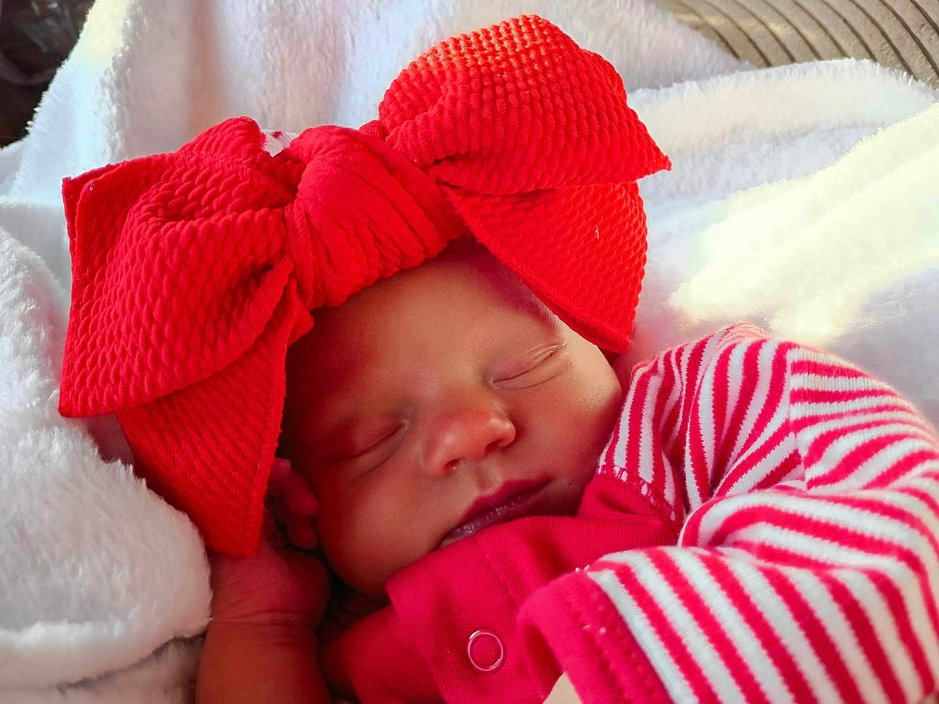 Phoenix joined the competition — help win amazing prizes! baby, sleeping, red_bow, striped_clothing, blanket, infant, cute, peaceful, face, headwear, cozy, soft, newborn, closeup, portrait, resting, child, indoors, warm, comfort