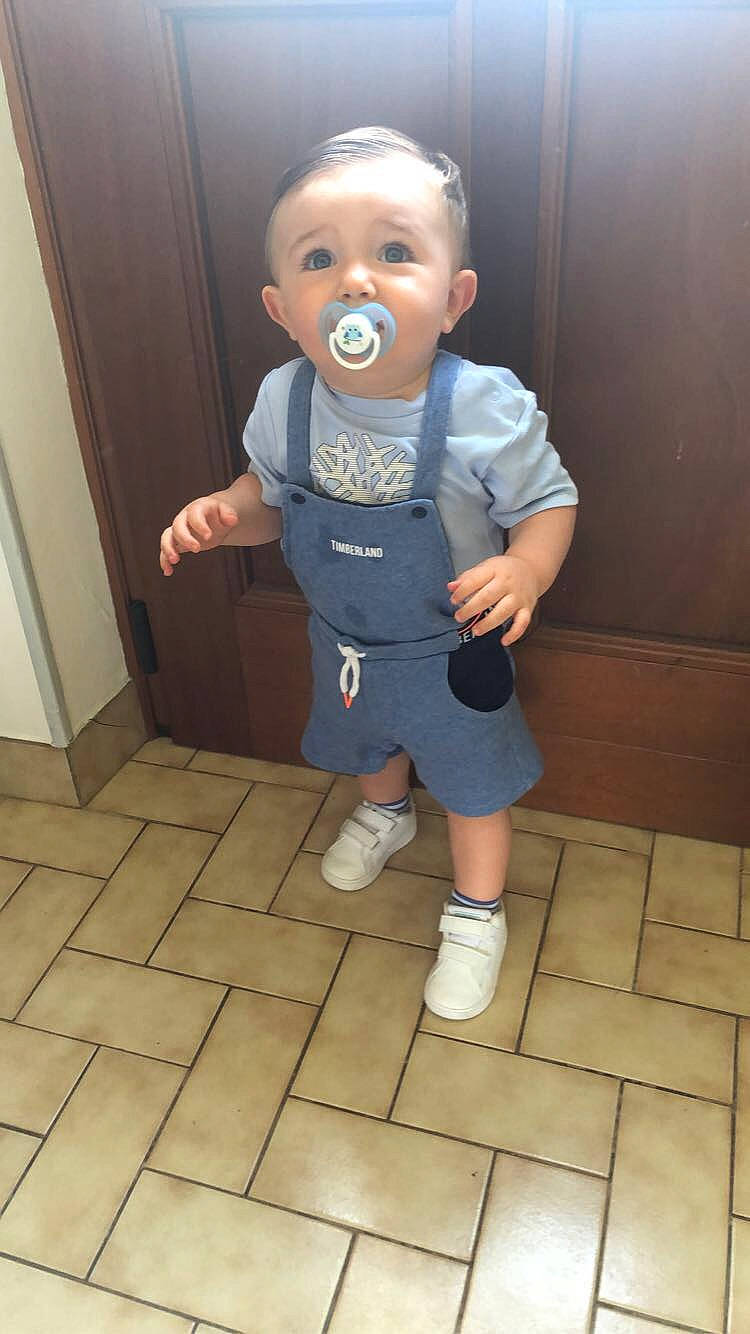 Aaron participe au concours pour gagner de l'argent avec cette photo : baby, baby_toddler_clothing, cheek, child, electric_blue, face, floor, flooring, fun, human_leg, knee, nose, person, shorts, sleeve, smile, sneakers, t_shirt, thigh, thumb