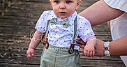 Coe joined the competition — help win amazing prizes! adult_hand, baby, blanket, bow_tie, child, cute, greenery, nature, outdoor, person, portrait, sandals, shorts, standing, summer_clothing, sunlight, support, suspenders, toddler, wooden_path