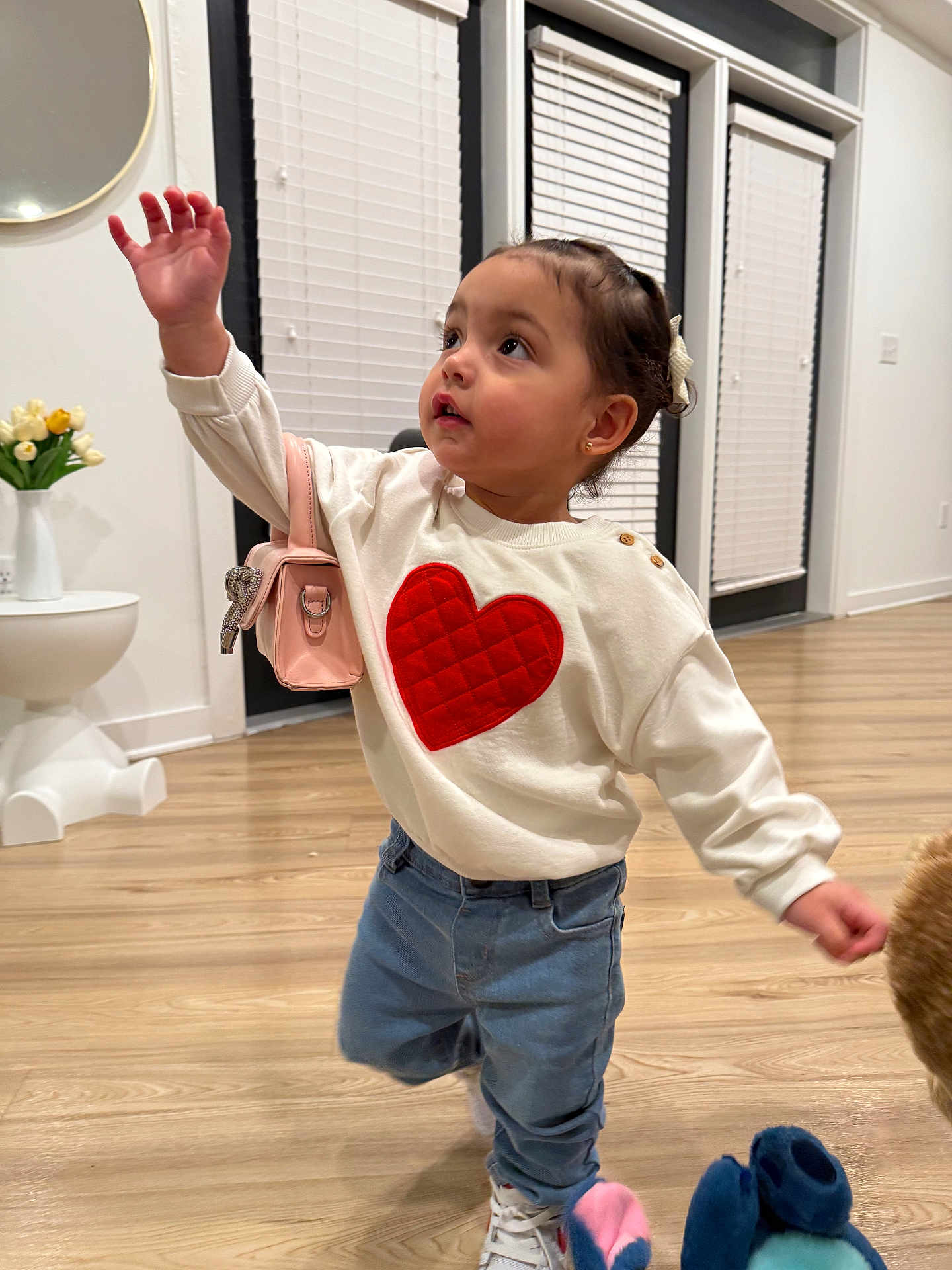 Maiya is registered to the contest to win money with this photo: toddler, child, indoor, sweater, heart, jeans, sneakers, purse, floor, wooden_floor, mirror, vase, tulips, curly_hair, earrings, white_walls, window_blinds, door, person, cute