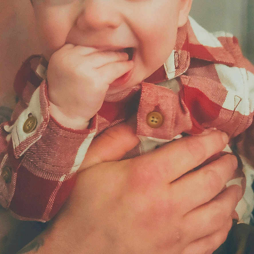 Rodger is registered to the contest to win money with this photo: baby, casual, child, closeup, cute, expression, face, fingers, hand, happy, holding, indoor, person, plaid_shirt, portrait, skin, smiling, tattoo, toddler, young_child