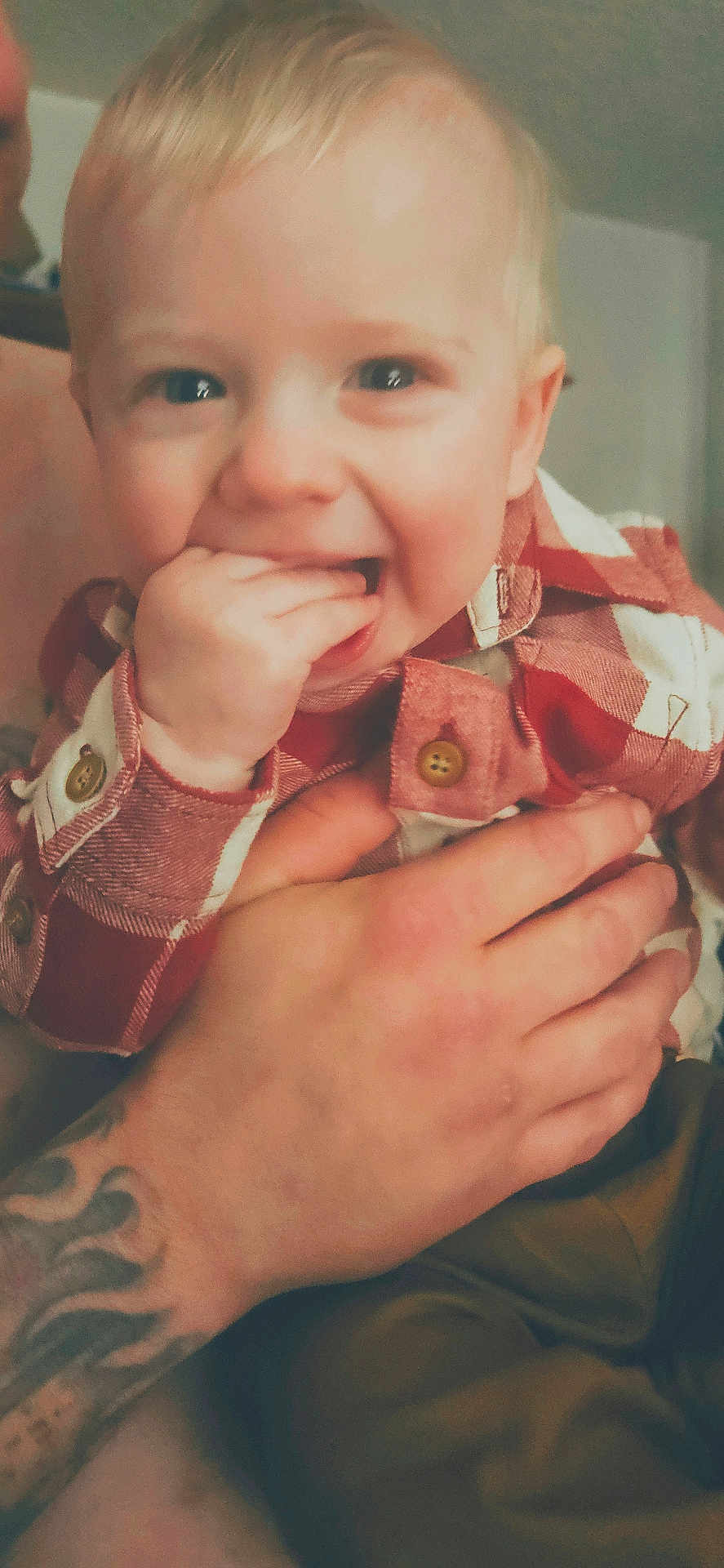 Rodger is registered to the contest to win money with this photo: toddler, child, baby, hand, tattoo, plaid_shirt, smiling, portrait, indoor, person, cute, happy, skin, fingers, holding, young_child, face, closeup, casual, expression