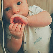 Rodger joined the competition — help win amazing prizes! baby, infant, onesie, hand, face, lying_down, cute, curious, skin, blue_eyes, clothing, child, newborn, toddler, shark_print, soft_lighting, indoors, portrait, close_up, peaceful
