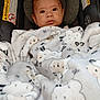 Raphael is registered to the contest to win money with this photo: baby, blanket, car_seat, child, infant, face, fur, pattern, comfort, cushion, warning_label, cute, expression, indoors, person, portrait, soft, young, wrapped, warm