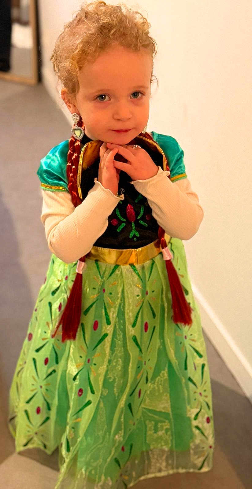 Dakota a rejoint le concours — aidez-le/la à gagner de superbes lots ! child, toddler, girl, costume, princess_dress, green_dress, braids, earrings, portrait, pose, hands, indoor, hallway, blonde, smile, cute, sparkle, fashion, young_child, curious