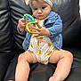 Nevaeh joined the competition — help win amazing prizes! baby, child, toy, couch, denim_jacket, headband, white_bow, romper, sun_pattern, sitting, indoor, skin, legs, feet, hand, face, expression, curious, leather, comfort