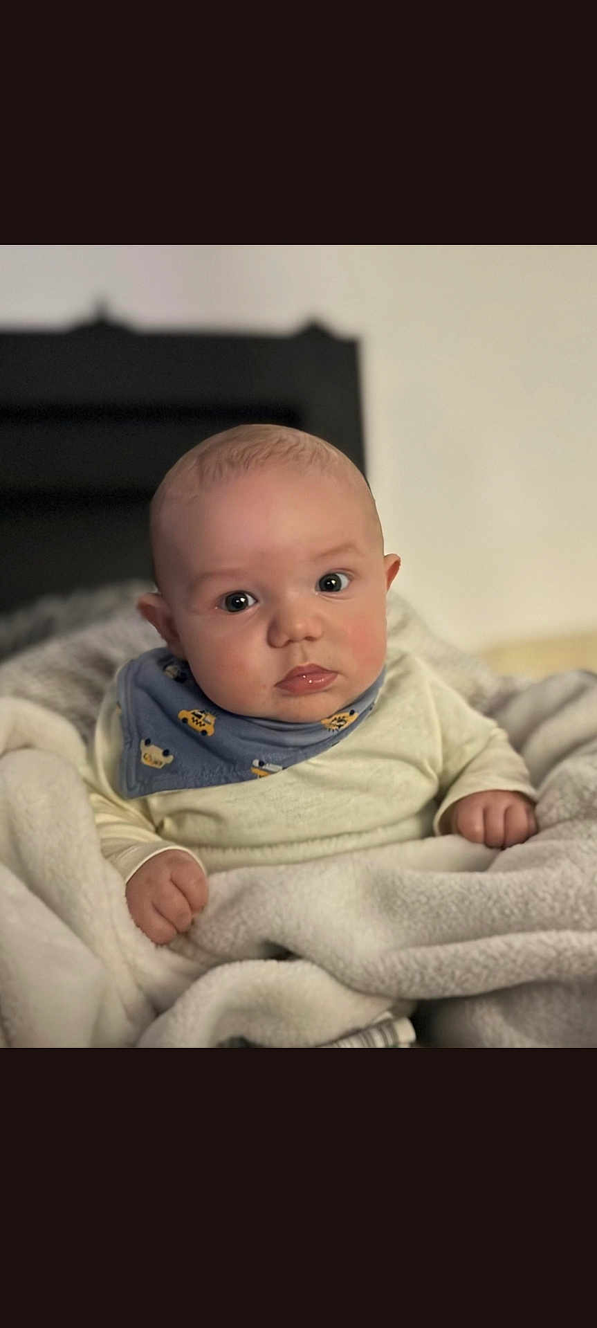 Kenny participe au concours pour gagner de l'argent avec cette photo : baby, infant, blanket, blue_bib, clothing, face, person, portrait, cute, chubby_cheeks, indoors, soft_texture, warm, child, young, sitting, curious, wide_eyes, head, hands