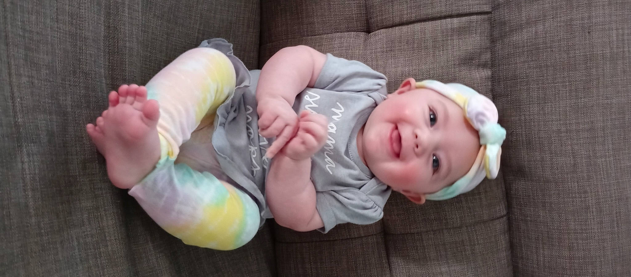 Lillyann is registered to the contest to win money with this photo: arm, baby, baby_toddler_clothing, cheek, comfort, finger, gesture, hand, head, headwear, human_body, mammal, mouth, nose, person, pink, product, skin, sleeve, smile