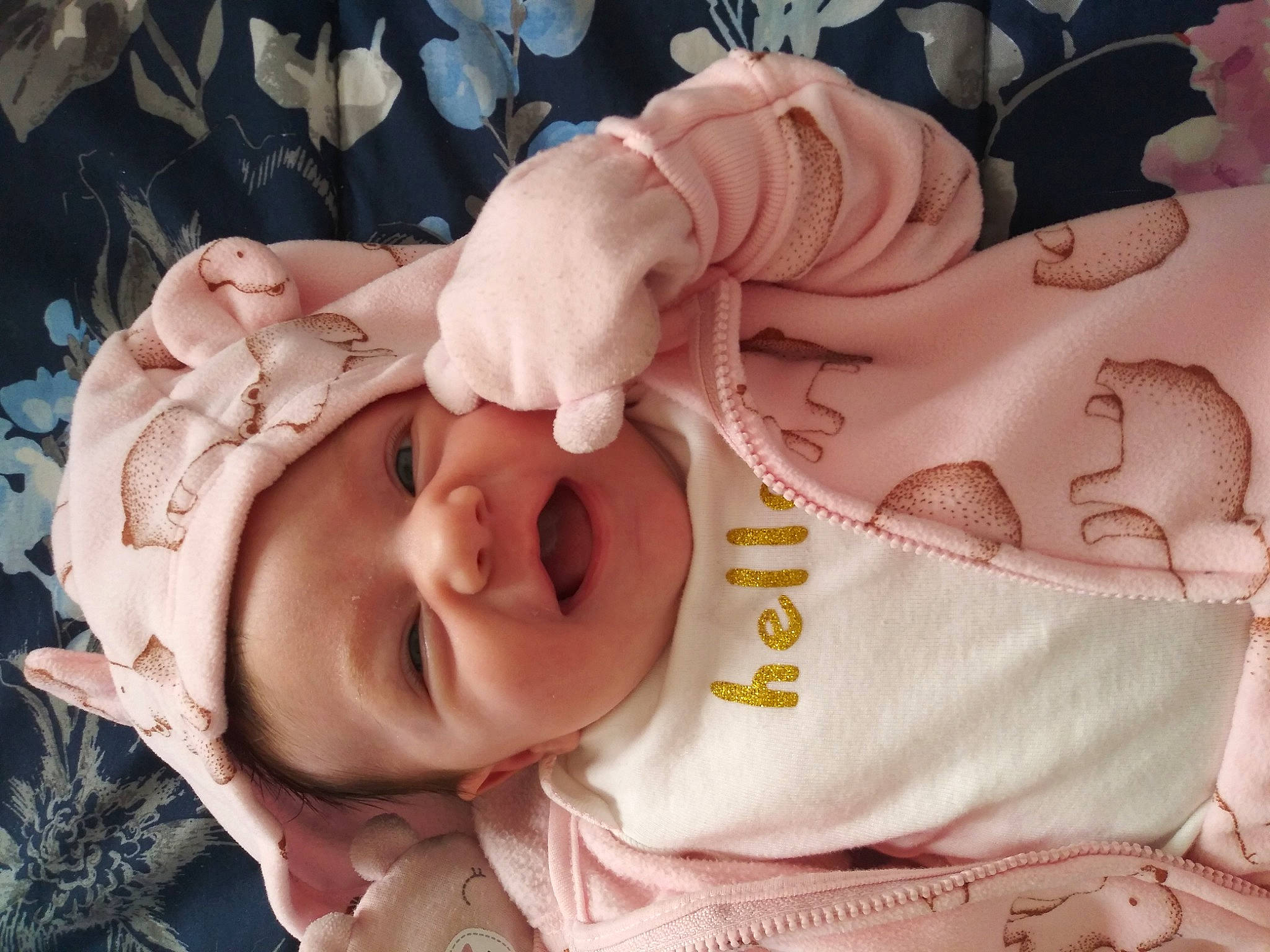 Lillyann is registered to the contest to win money with this photo: arm, baby, baby_toddler_clothing, cheek, ear, eye, finger, gesture, hand, happy, head, headgear, human_body, mouth, muscle, nose, person, pink, skin, smile