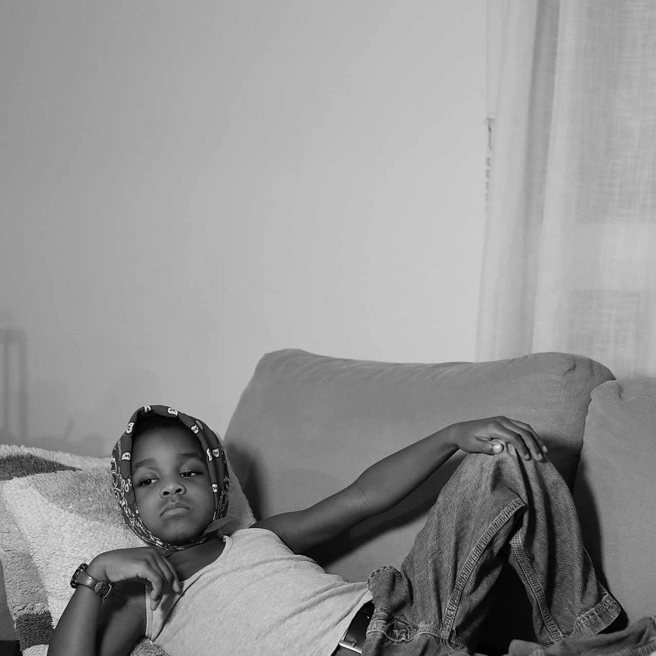 Ceyhan a rejoint le concours — aidez-le/la à gagner de superbes lots ! black_and_white, casual, child, couch, expression, furniture, headscarf, home, indoor, jeans, leisure, monochrome, person, pillow, portrait, relaxed, resting, tank_top, watch, young