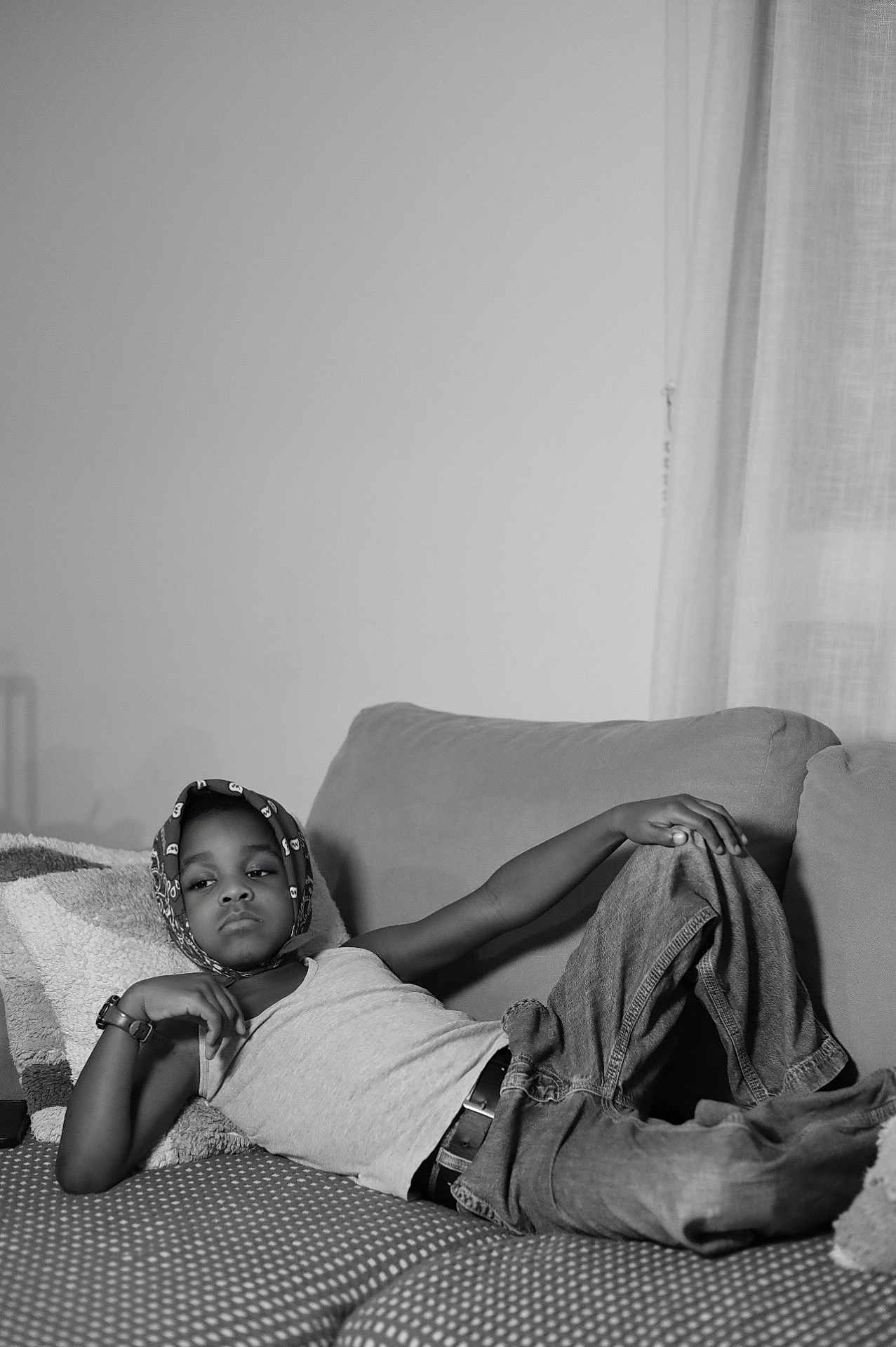 Ceyhan a rejoint le concours — aidez-le/la à gagner de superbes lots ! child, black_and_white, couch, relaxed, headscarf, tank_top, jeans, watch, indoor, portrait, casual, home, furniture, pillow, monochrome, person, young, resting, leisure, expression